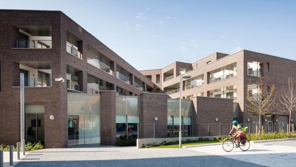 SW9 community housing - a cyclist passing a block of flats
